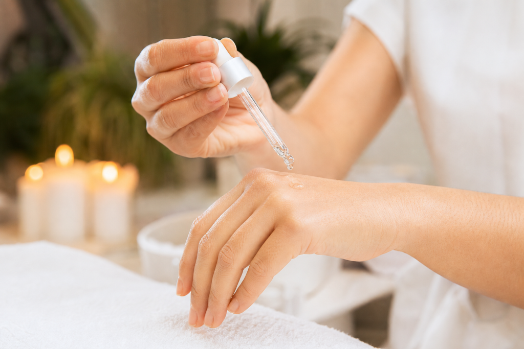 Hands applying hyaluronic serum showing hydrated skin texture
