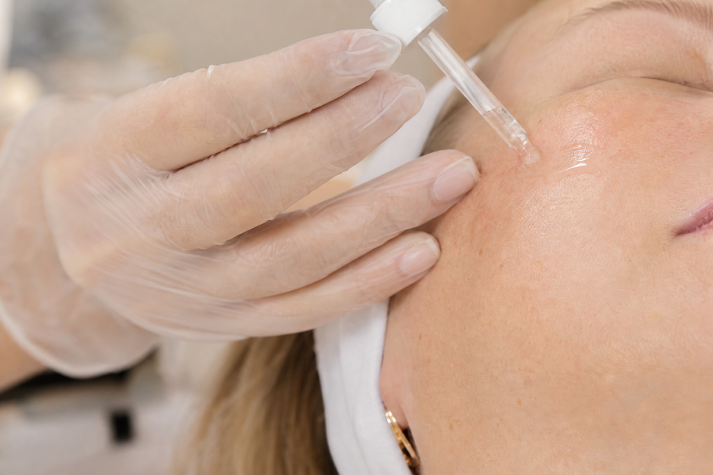 Application of lightweight hydrating serum during a professional facial.