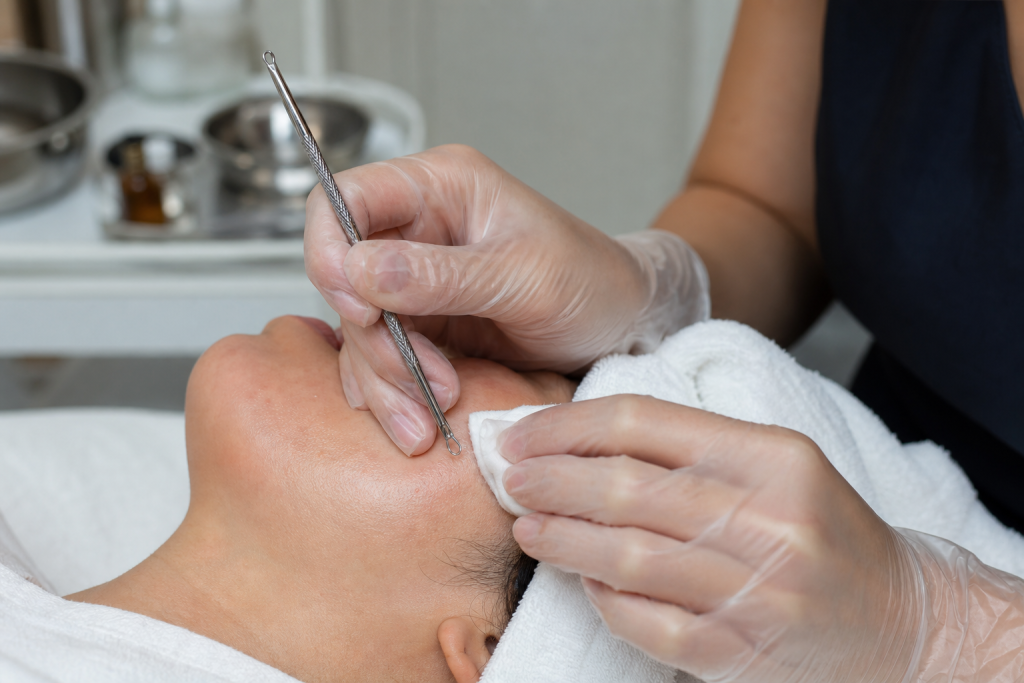 Licensed clinician performing a gentle manual extraction on a client's nose using sterilized tools.