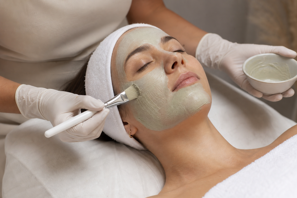 Esthetician applying a soothing face mask during a professional facial.